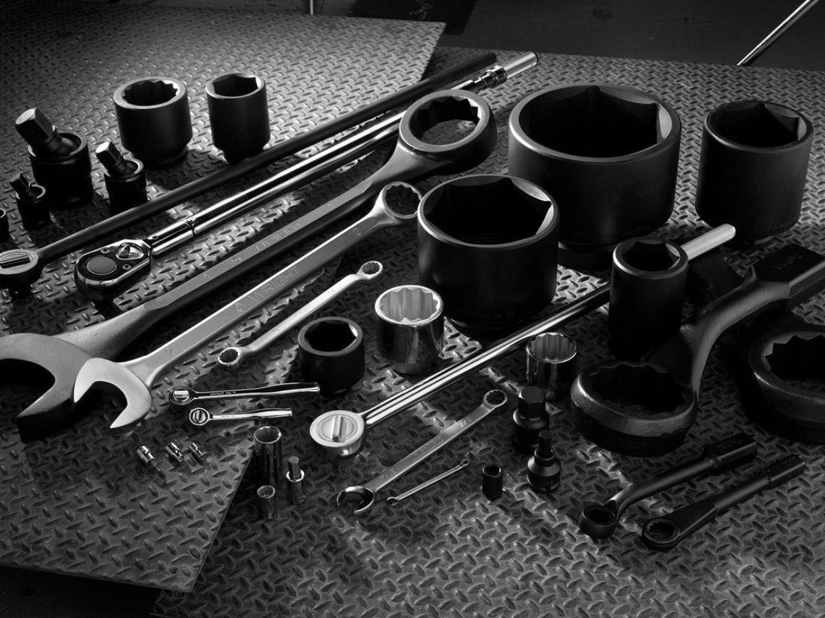Combination spanners, torque wrench and impact sockets on a workshop floor