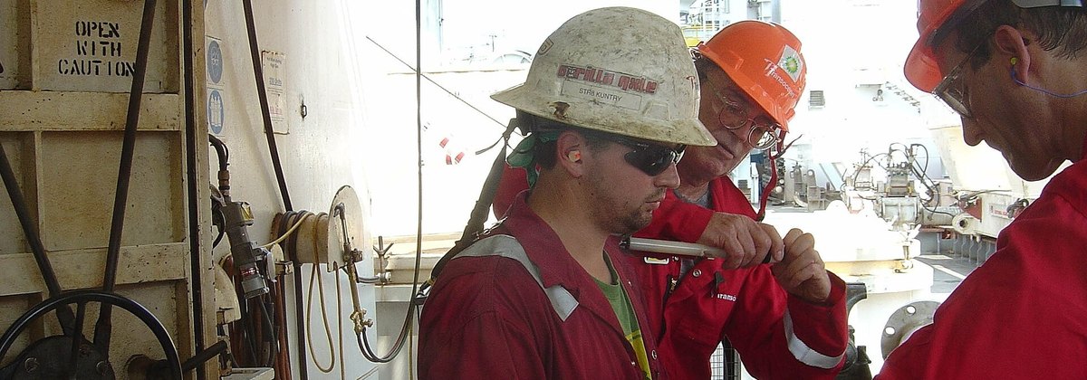 Crew in PPE working with equipment on an offshore rig